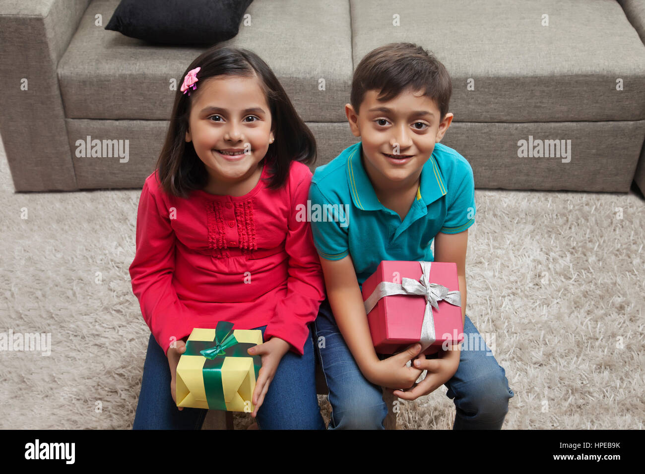 Brother and sister holding présente dans la salle de séjour Banque D'Images