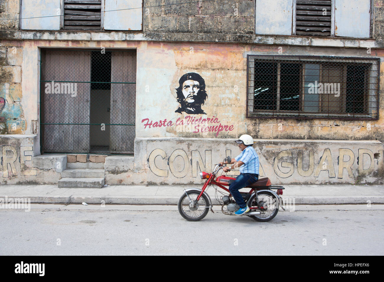 Portrait d'homme transgenre Juani Santos (64) équitation sa moto à l'avant du Che Guevara murale dans sa ville natale de Matanzas, Cuba. Juani a été bo Banque D'Images