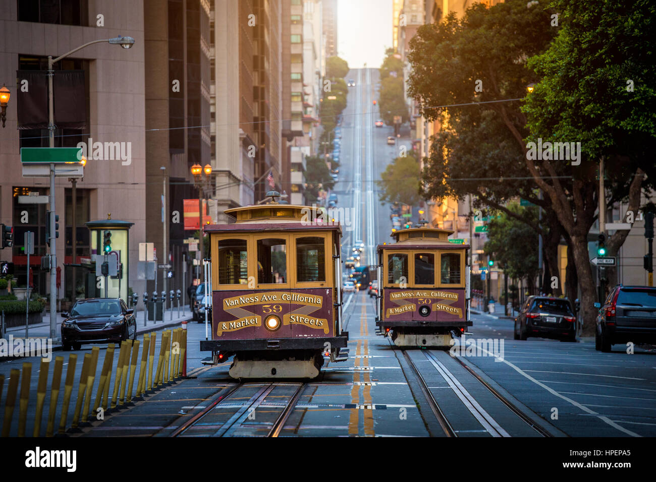 La vue classique du câble traditionnel historique voitures rouler sur la célèbre rue de la Californie dans la belle lumière du matin au lever du soleil en été, San Francisco, États-Unis Banque D'Images