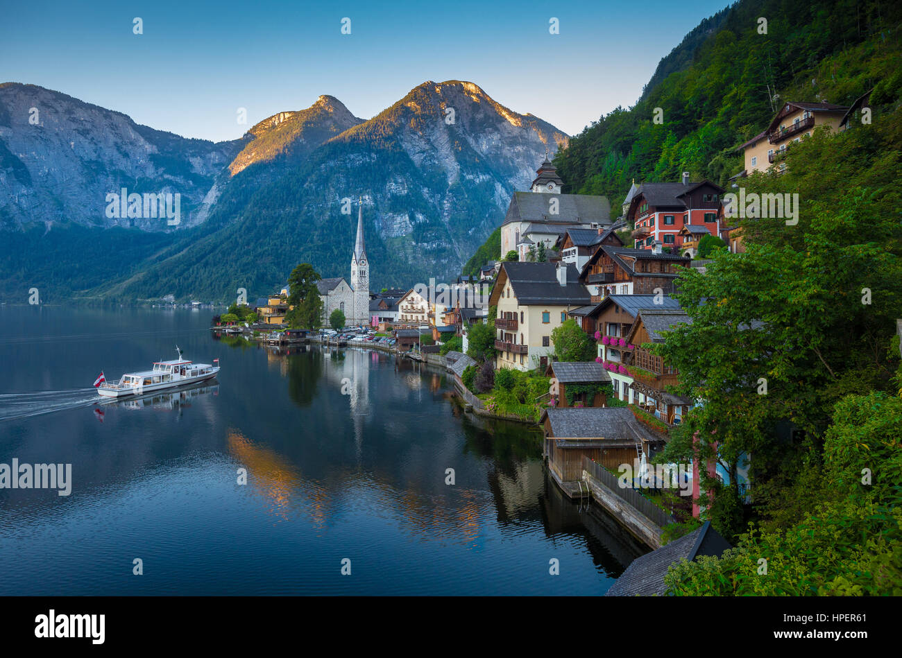 Vue de carte postale classique de la célèbre ville au bord du lac de Hallstatt dans les Alpes avec des navires à passagers de tôt le matin à l'aube de la lumière en été, Autriche Banque D'Images