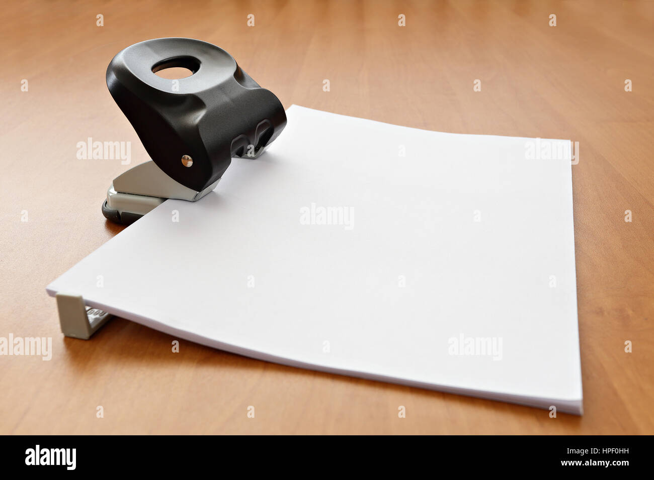 Black Hole puncher avec le papier sur bois table office Banque D'Images