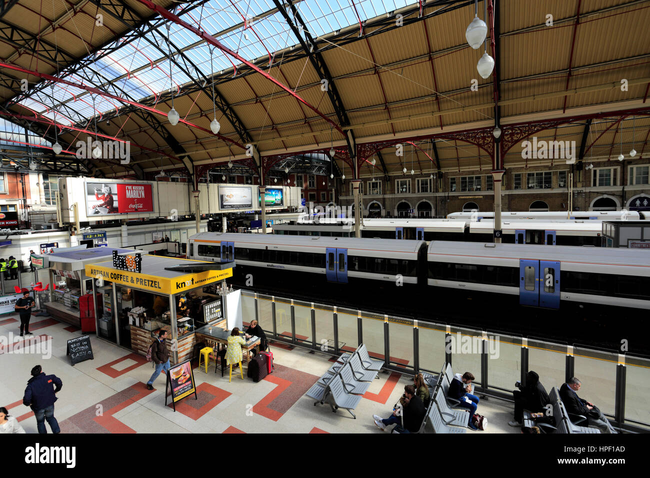 Les gens dans le grand hall et tableaux des départs ; à l'intérieur de la gare de Victoria, London UK Banque D'Images