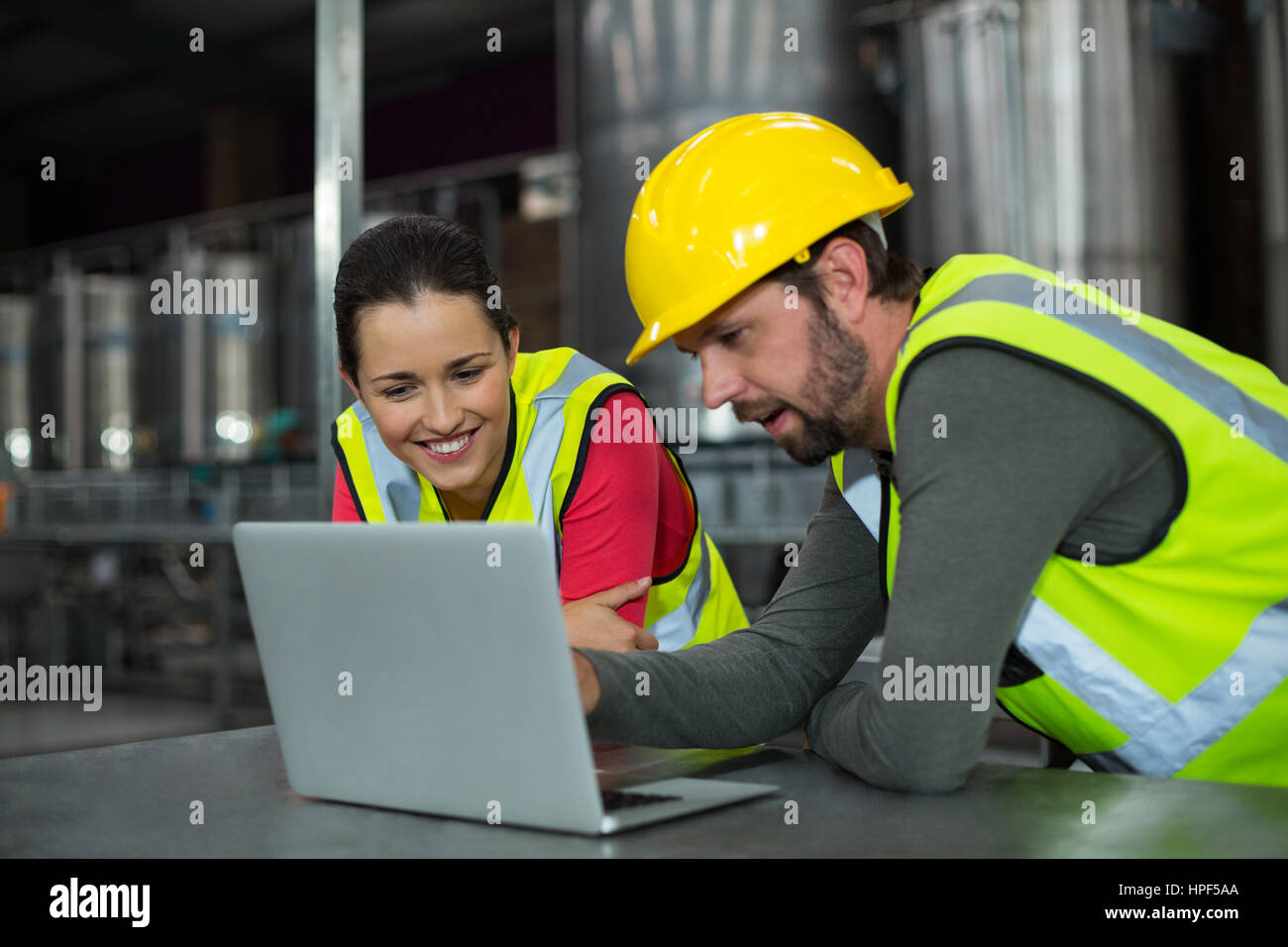 Les travailleurs d'usine à l'aide de tablette numérique à l'usine de production de boissons Banque D'Images