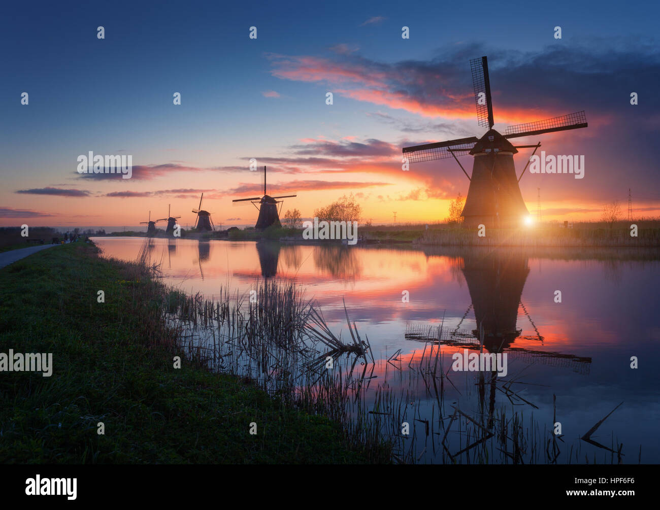 Silhouette de moulins à vent au lever du soleil dans le brouillard incroyable Kinderdijk, Pays-Bas. Paysage avec moulins à vent hollandais rustique près du ciel coloré et canaux Banque D'Images
