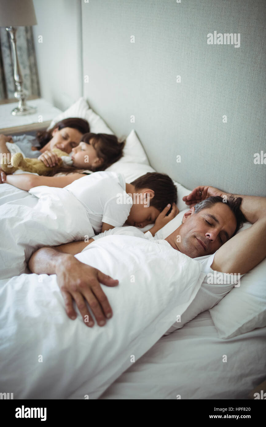 Les parents et les enfants de dormir sur le lit chez lui Photo Stock - Alamy