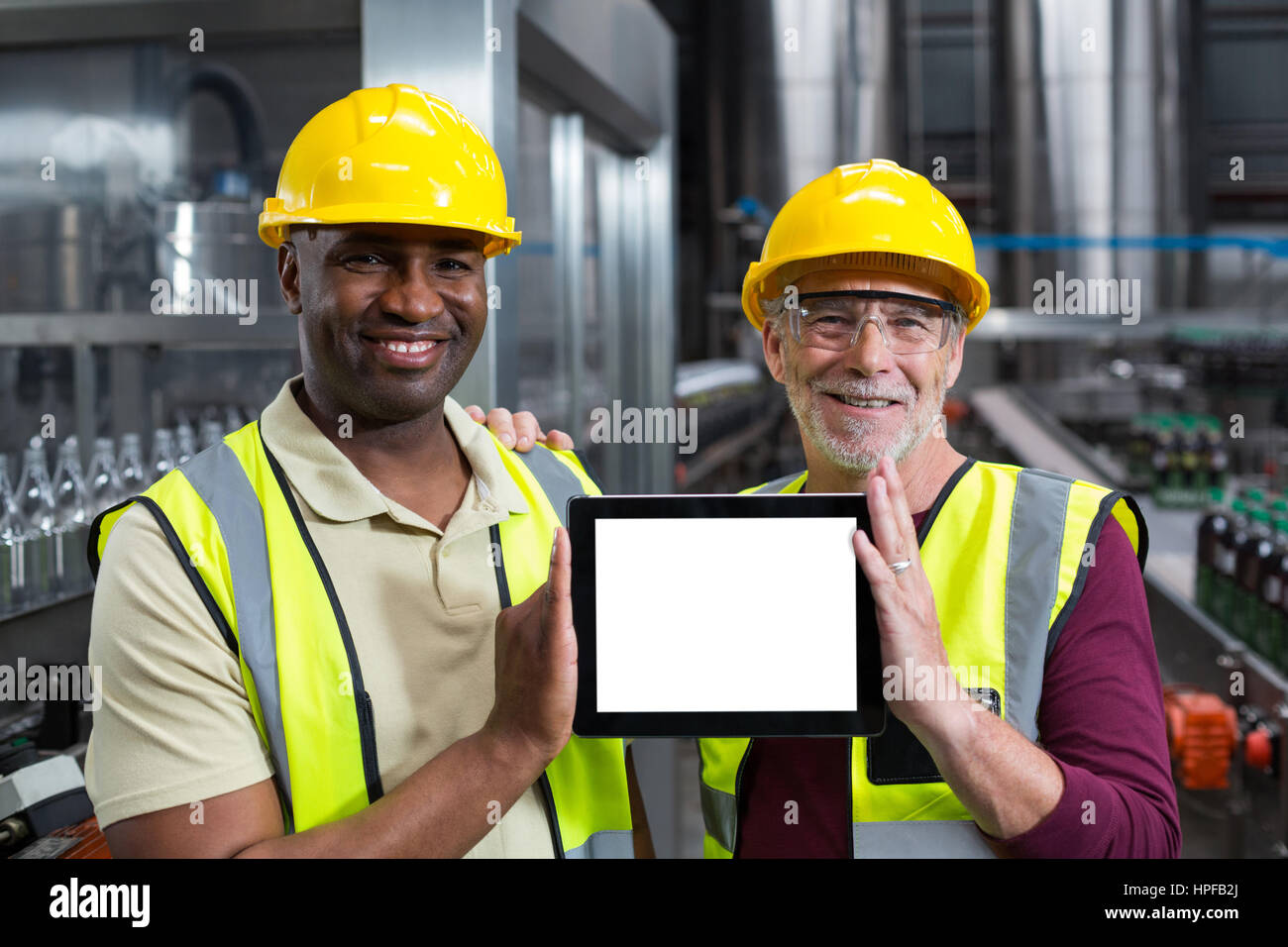 Portrait de travailleurs d'usine holding digital tablet à l'usine de production de boissons Banque D'Images