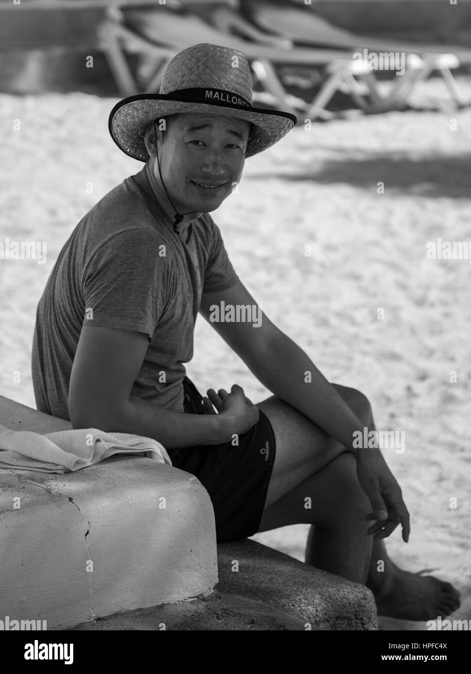 Les gens simples,naturel réel font de leur routine quotidienne. Homme Portreture...Chineze reposant à plage de Cala d''or, profiter de la vue...sourire... Banque D'Images