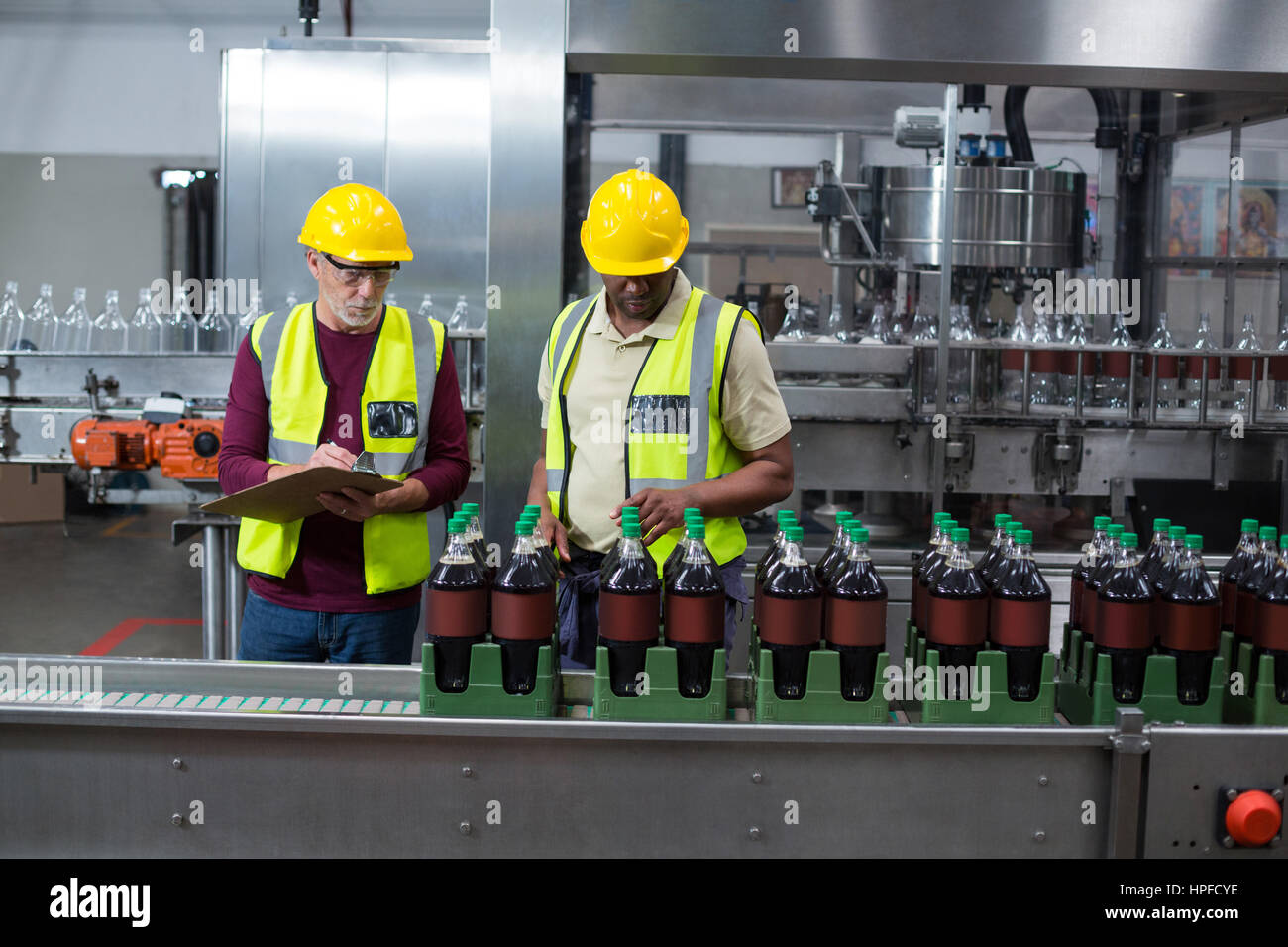 Deux travailleurs de l'usine de bouteilles verre froid de surveillance à l'usine de production de boissons Banque D'Images