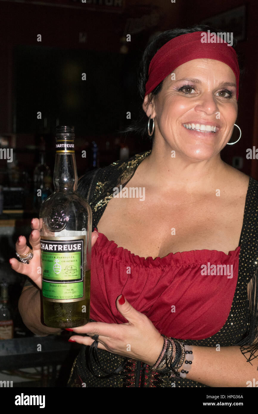 Barman femme hispanique vêtu d'un costume de Halloween gitane tenant une bouteille de Chartreuse verte. Cumberland Wisconsin WI USA Banque D'Images