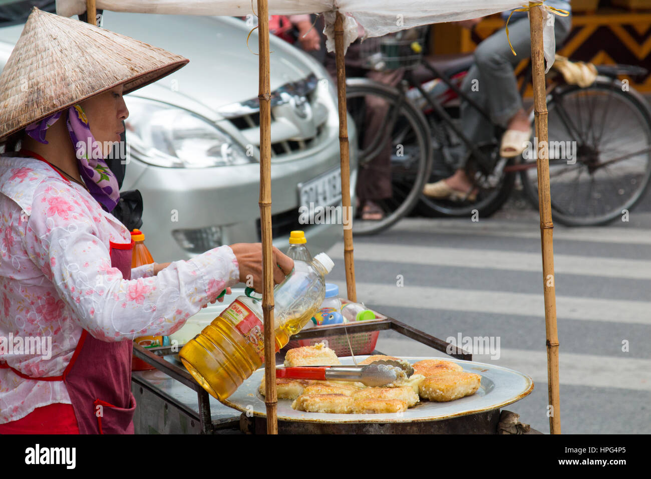 Dame vietnamienne Cuisine vendeur beignets de maïs et de les vendre dans la rue à Hanoi old quartyer,Vietnam,Asia Banque D'Images