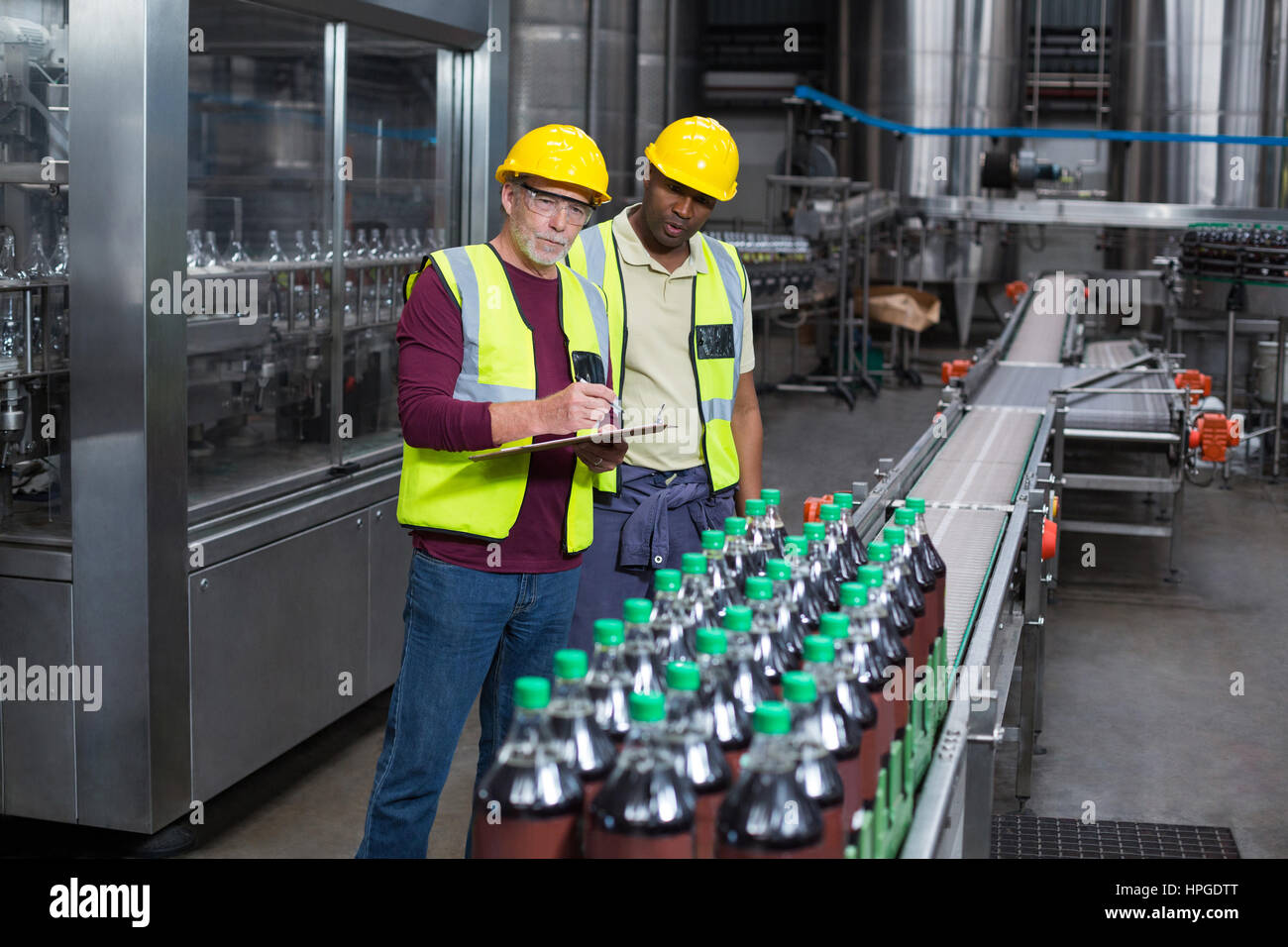 Deux travailleurs de l'usine de bouteilles verre froid de surveillance à l'usine de production de boissons Banque D'Images