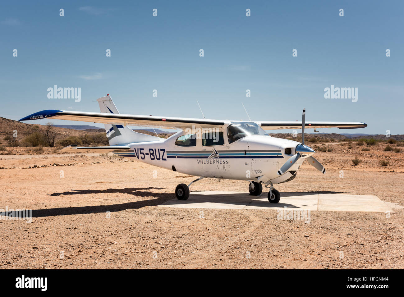 Un Cessna 210, l'inscription V5-Buz, assis sur l'aviation à Doro Nawas dans le nord-ouest de la Namibie. Il est peint dans les couleurs de l'air en milieu sauvage. Banque D'Images