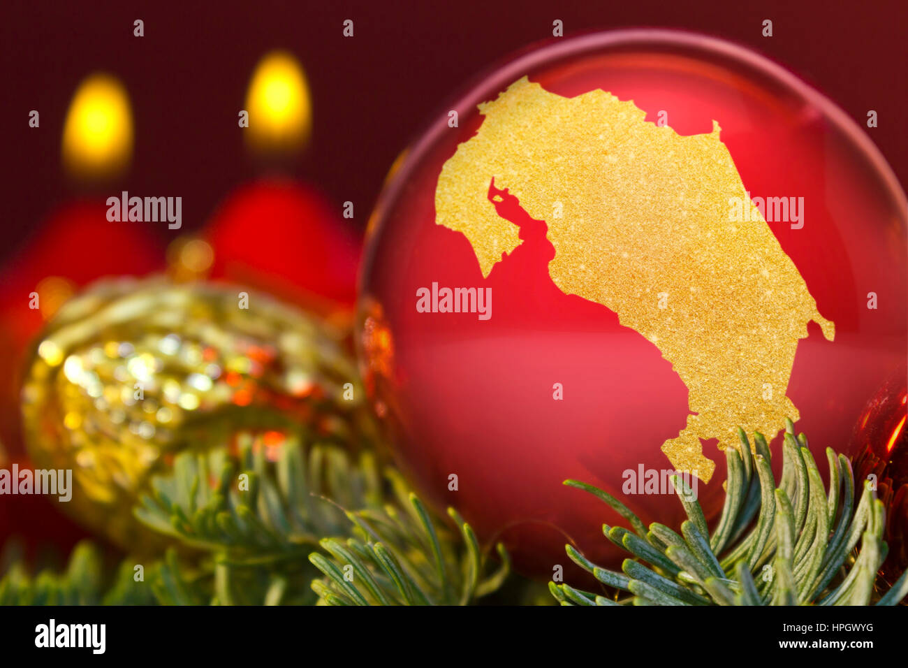 Une babiole rouge brillant avec la forme d'or du Costa Rica.(série) Banque D'Images