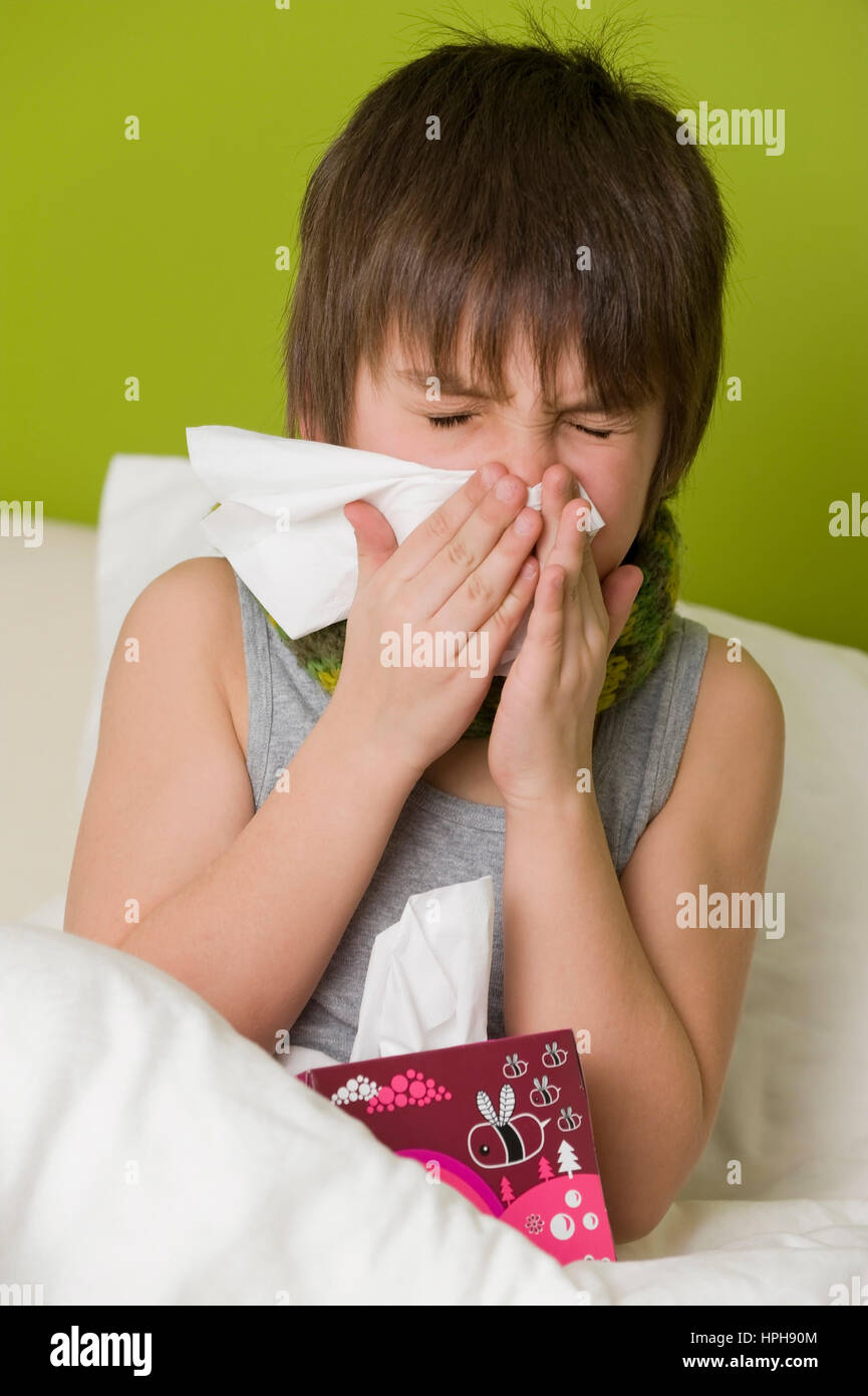 Schneuzt Junge Kranker sich im Bett - garçon malade au lit ses coups de nez, modèle publié Banque D'Images
