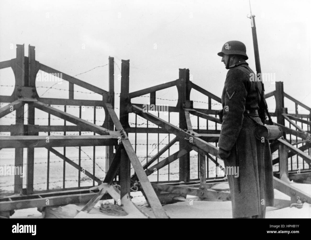 L'image de propagande nazie montre un sentinelle allemand de Wehrmacht devant des barrières anti-chars sur le mur de l'Atlantique. Publié en février 1944. Fotoarchiv für Zeitgeschichte - PAS DE SERVICE DE FIL - | utilisation dans le monde entier Banque D'Images