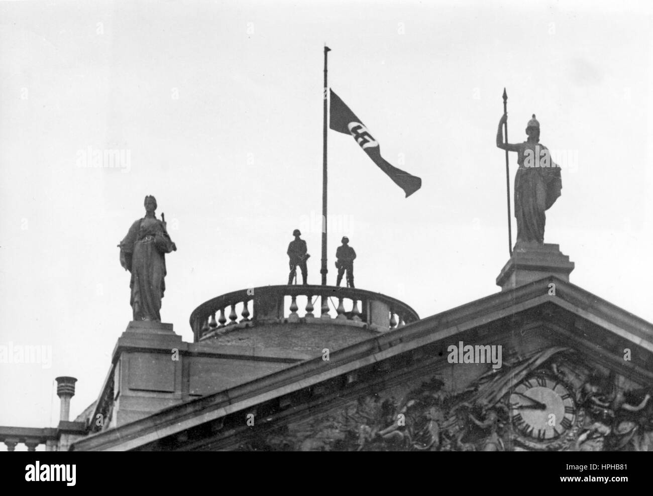 L'image de propagande nazie montre des soldats allemands de Wehrmacht à côté d'un drapeau Swastika surélevé sur le toit du Palais royal belge de Laeken à Bruxelles occupée, Belgique. Pris en mai 1940. Fotoarchiv für Zeitgeschichte - PAS DE SERVICE DE FIL - | utilisation dans le monde entier Banque D'Images