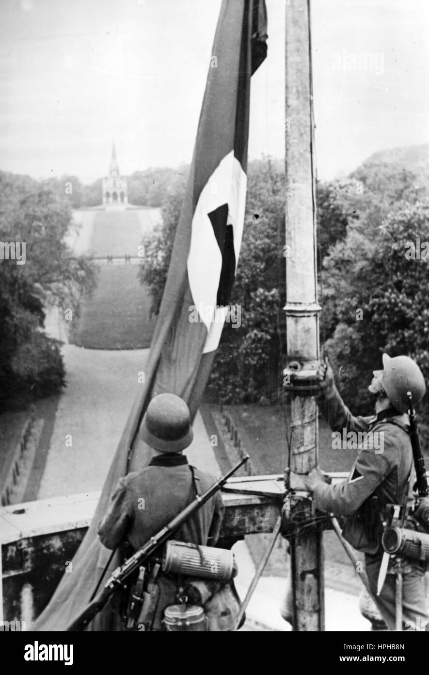 L'image de propagande nazie montre des soldats allemands de Wehrmacht à côté d'un drapeau Swastika surélevé sur le toit du Palais royal belge de Laeken à Bruxelles occupée, Belgique. Pris en mai 1940. Fotoarchiv für Zeitgeschichte - PAS DE SERVICE DE FIL - | utilisation dans le monde entier Banque D'Images