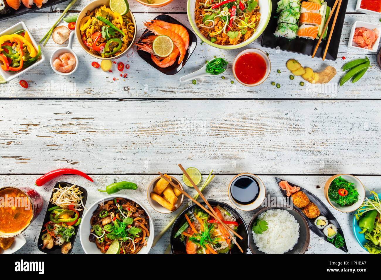 La nourriture asiatique servi sur table en bois blanc, vue du dessus, de l'espace pour le texte. La cuisine vietnamienne et chinoise. Banque D'Images
