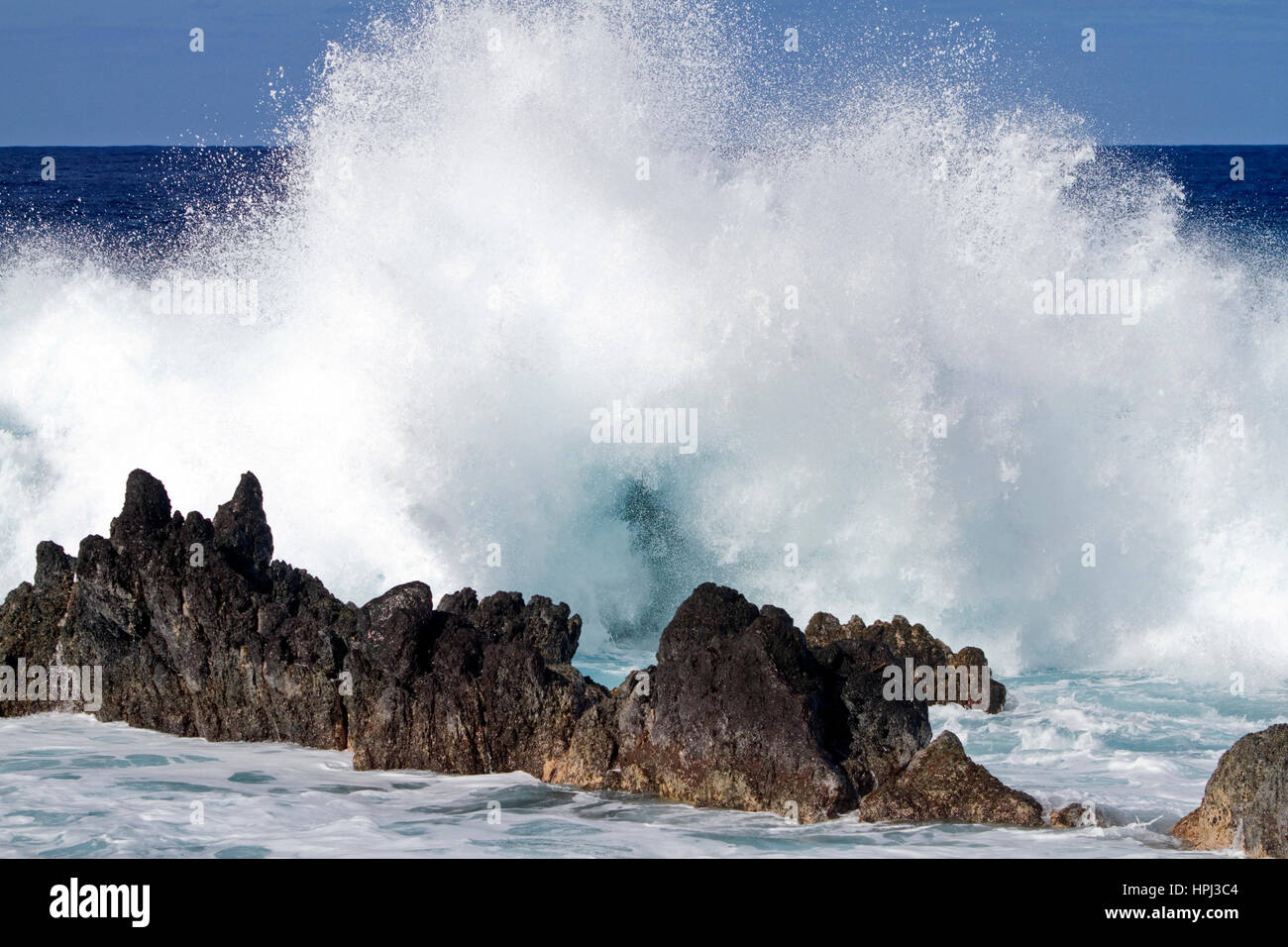 Les vagues déferlent sur la côte rocheuse sur la grande île de Hawaii, USA. Banque D'Images