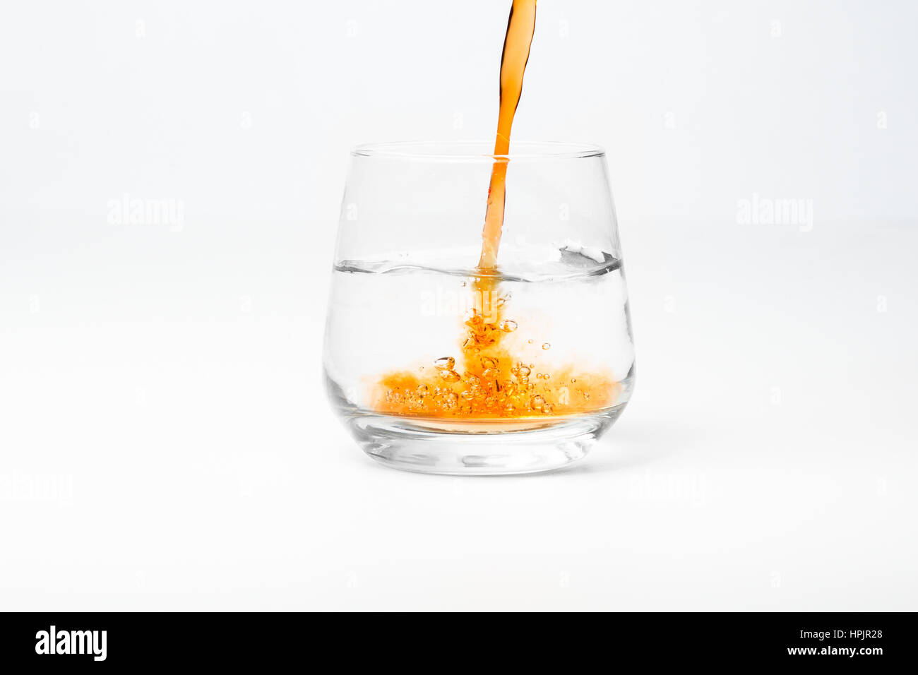 Ice Tea verser dans le verre avec de l'eau isolated on white Banque D'Images