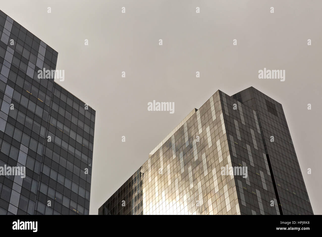 Des détails architecturaux d'un gratte-ciel moderne avec une façade en verre coloré reflétant le bleu du ciel un jour d'été jusqu'à la vue d'en bas, coucher du soleil Banque D'Images
