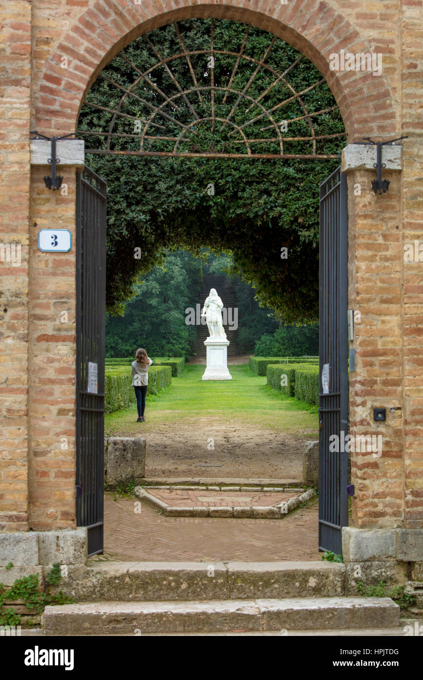 Jeune fille à l'entrée de l'Horti Leonini Jardin avec la statue du Grand-duc Cosme III de Médicis, San Quirico d'Orcia, Toscane, Italie Banque D'Images