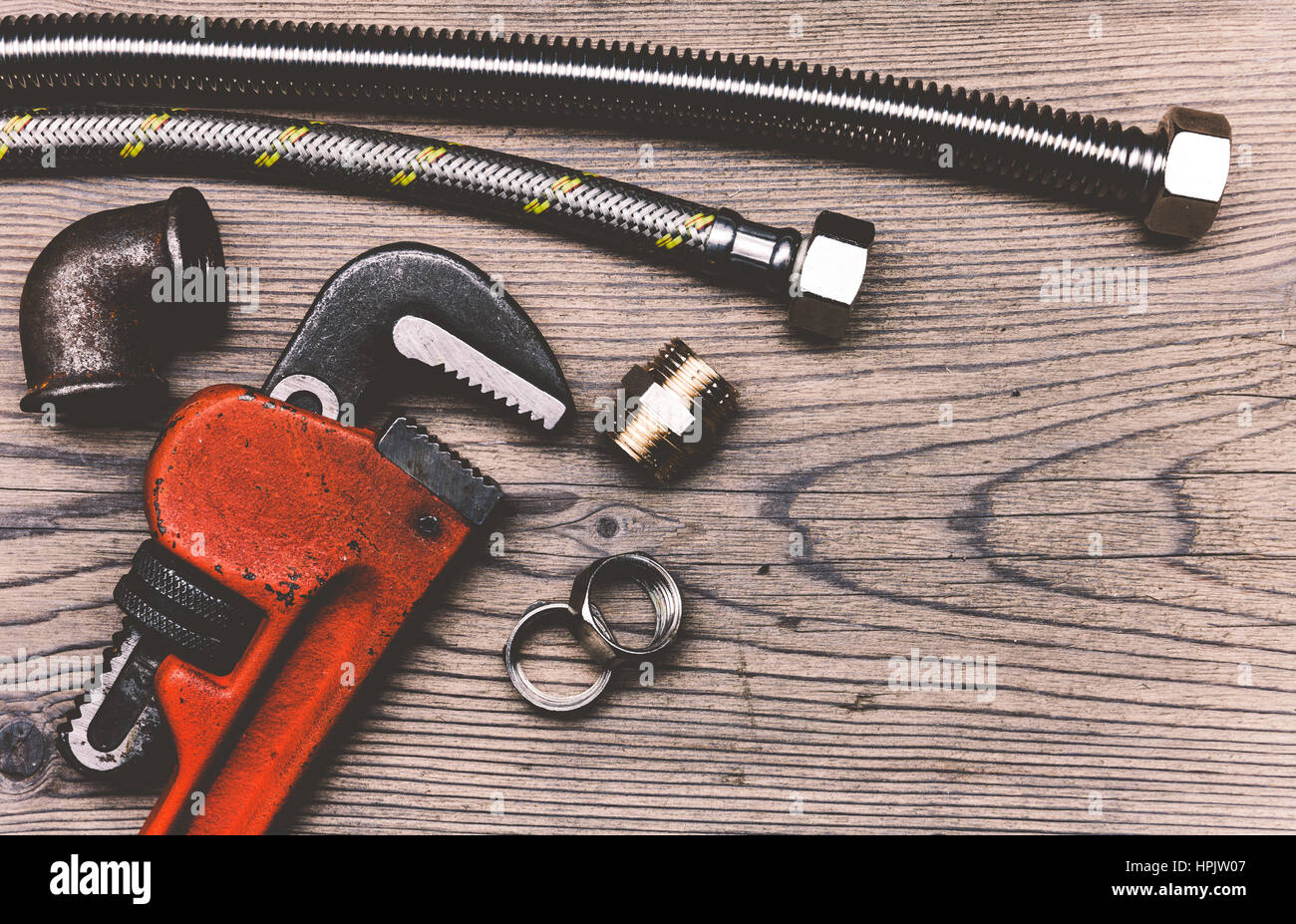 Outils de plomberie tuyaux raccords et carte d'affaires sur le fond de la surface en bois Banque D'Images