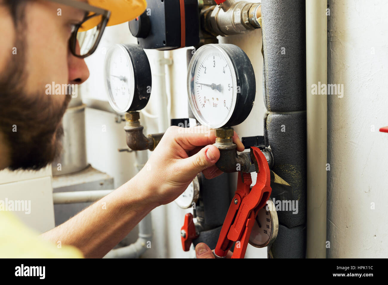 Plombier installation compteur de pression pour système de chauffage maison Banque D'Images