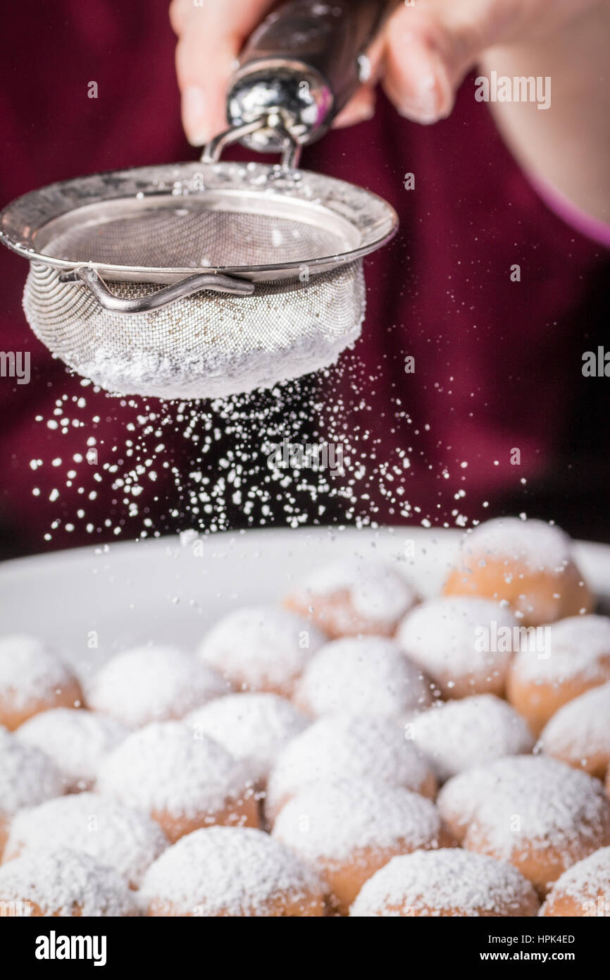 Saupoudrer de sucre en poudre sur des gâteaux Banque D'Images