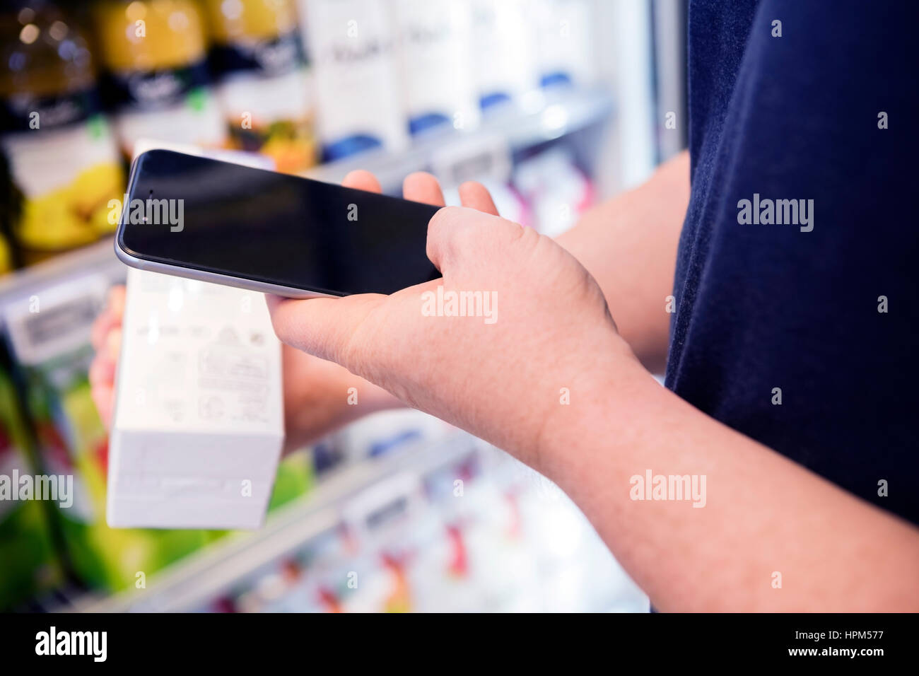 Portrait de l'homme de la numérisation du code-barres d'un produit par le biais de smart phone in supermarket Banque D'Images