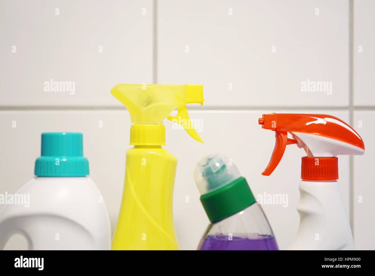 Différents produits de nettoyage et des détergents en face de carreaux de salle de bain blanche avec copie espace Banque D'Images