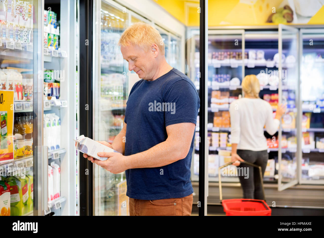 Client de sexe masculin jus holding paquet lors de l'article in grocery store Banque D'Images