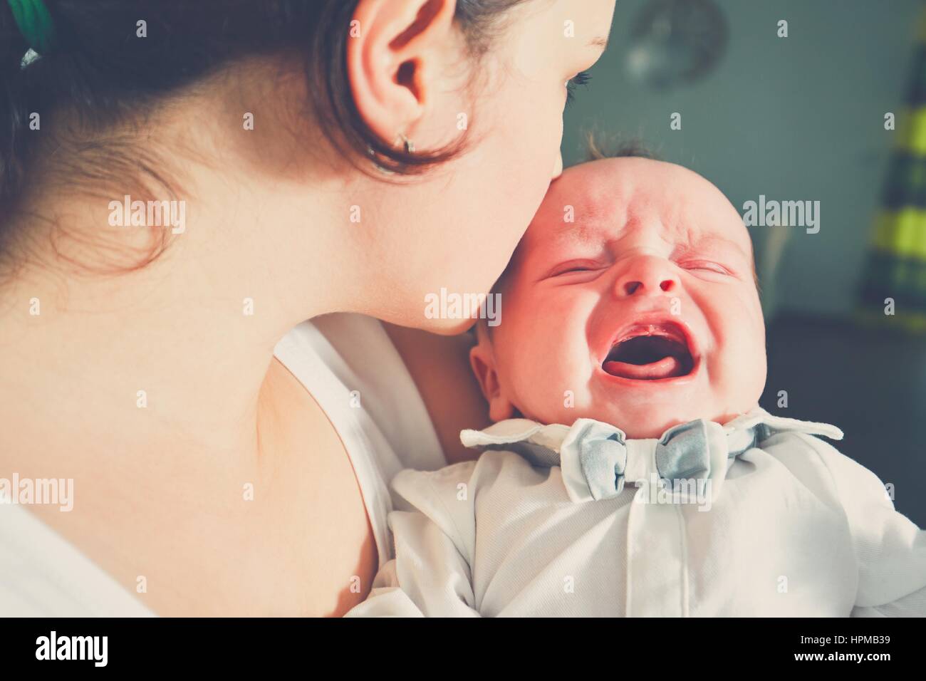 Mère tenant bébé qui pleure. Jeune femme avec son petit fils. Banque D'Images