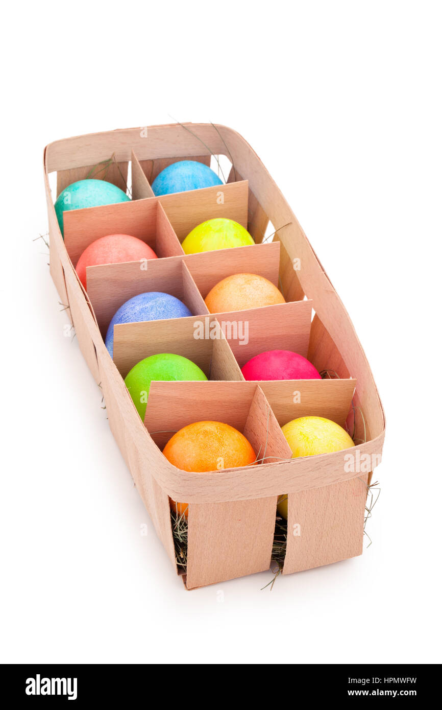 Les oeufs de Pâques colorés dans le panier rustique. Isolé sur fond blanc. Banque D'Images Les oeufs de Pâques colorés dans le panier rustique. Isolé sur fond blanc. Banque D'Images