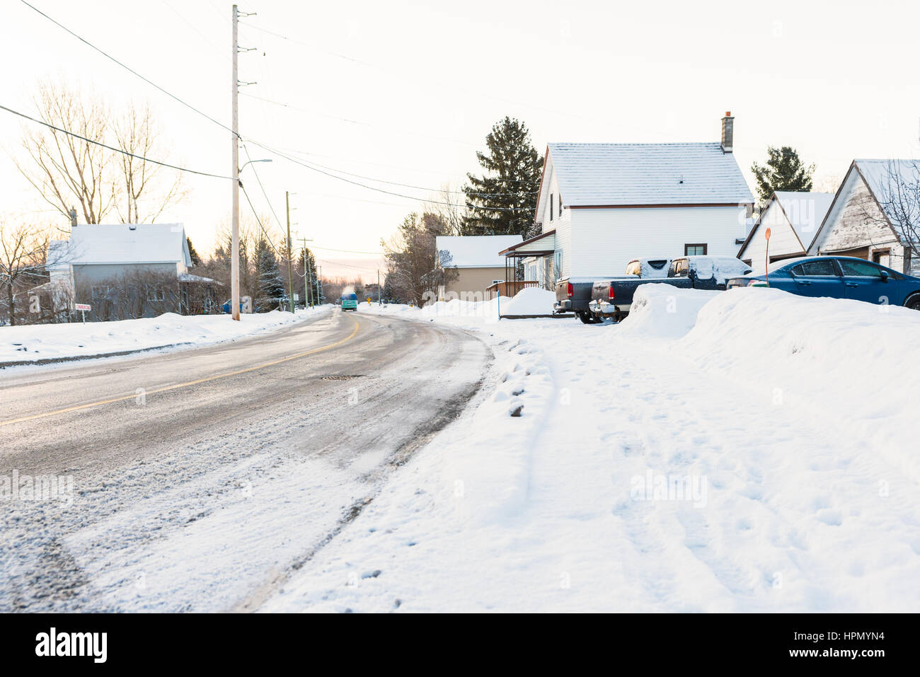 Maisons et voitures couvertes de neige dans des conditions sous-zéro dans les pays ville en hiver Banque D'Images