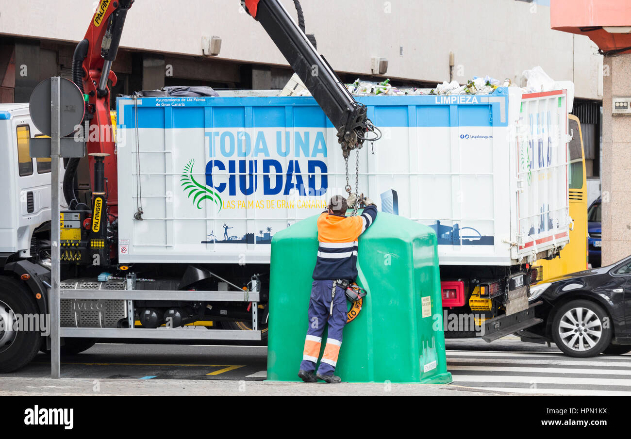 Le recyclage de l'Espagne. Travailleur du conseil vider récipient plein de bouteilles en verre en ville rue en Espagne. Banque D'Images