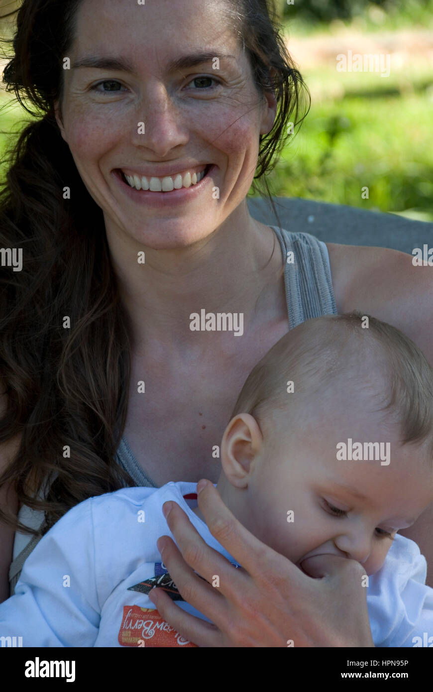 Femme jouant, les baisers et aimant son petit garçon sur le jardin Banque D'Images