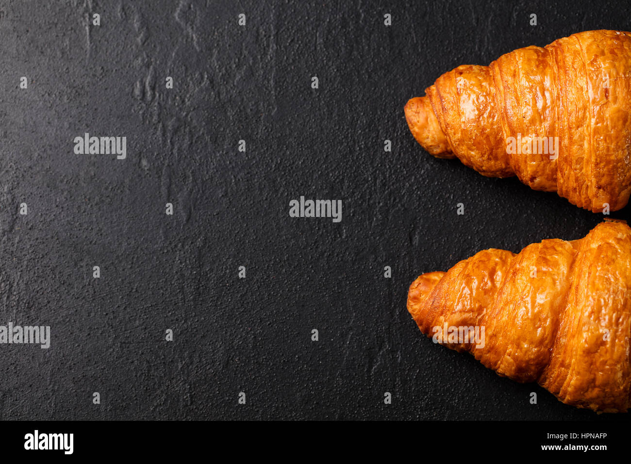 Croissant frais sur un fond en ardoise noire. Top View Copy space Banque D'Images