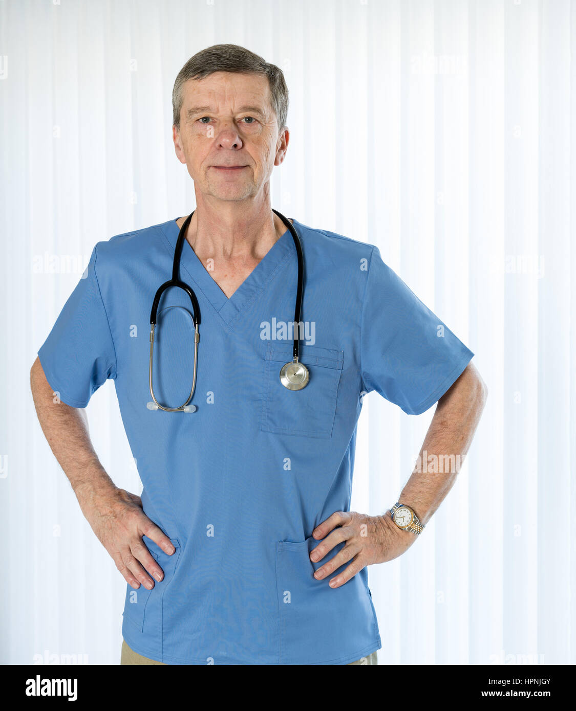 Senior male hispanic doctor with stethoscope dans scrubs medical et confiance face à l'appareil photo en mode portrait Banque D'Images