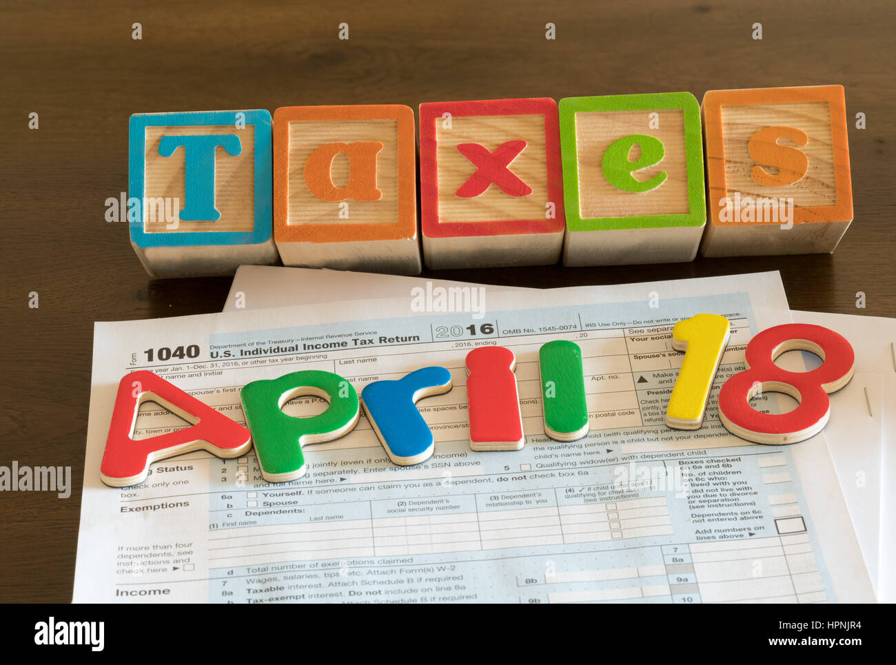 Lettres en bois sur le dessus de l'impôt sur le revenu 1040 formulaire pour 2016 Taxe de dépôt jour montrant le 18 avril 2017 est Banque D'Images