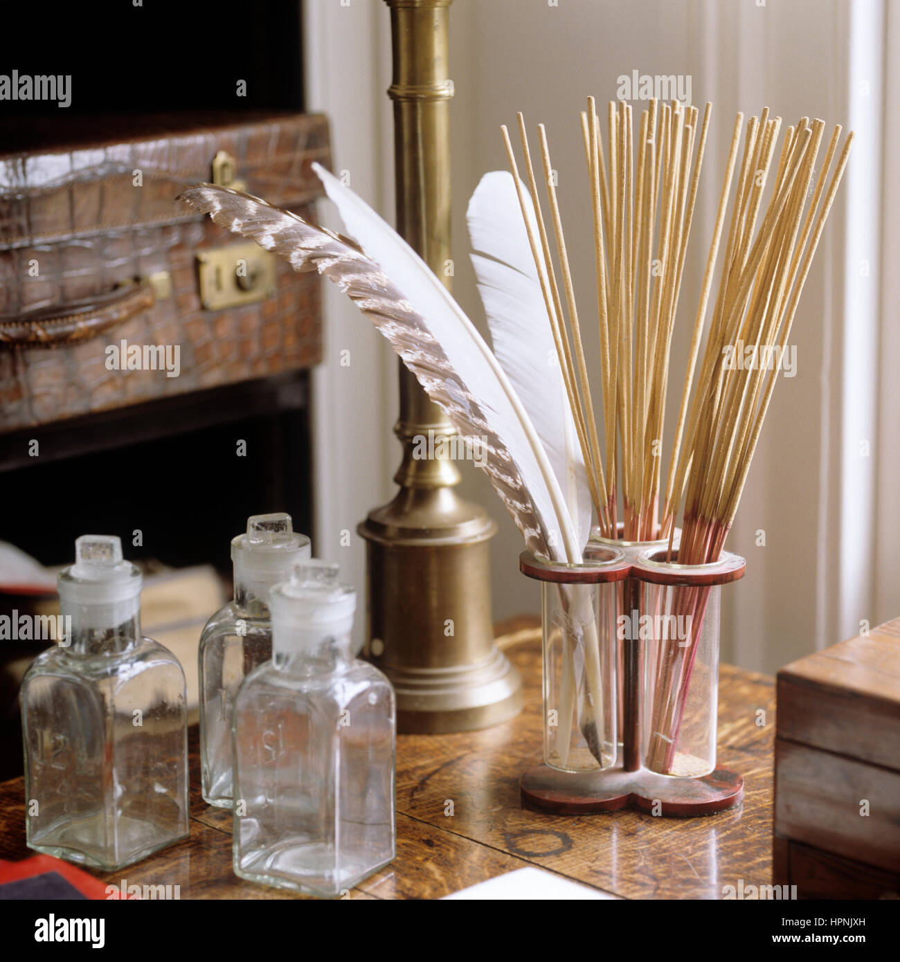 'Une petite table avec des flacons en verre, des plumes et des bâtons." Banque D'Images