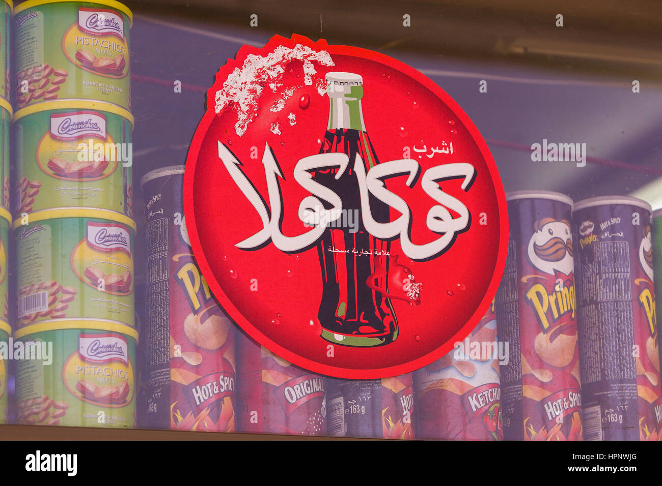 AL AIN, ÉMIRATS ARABES UNIS - Rouge Coca-cola inscription en arabe, montrant une bouteille de coke. Banque D'Images