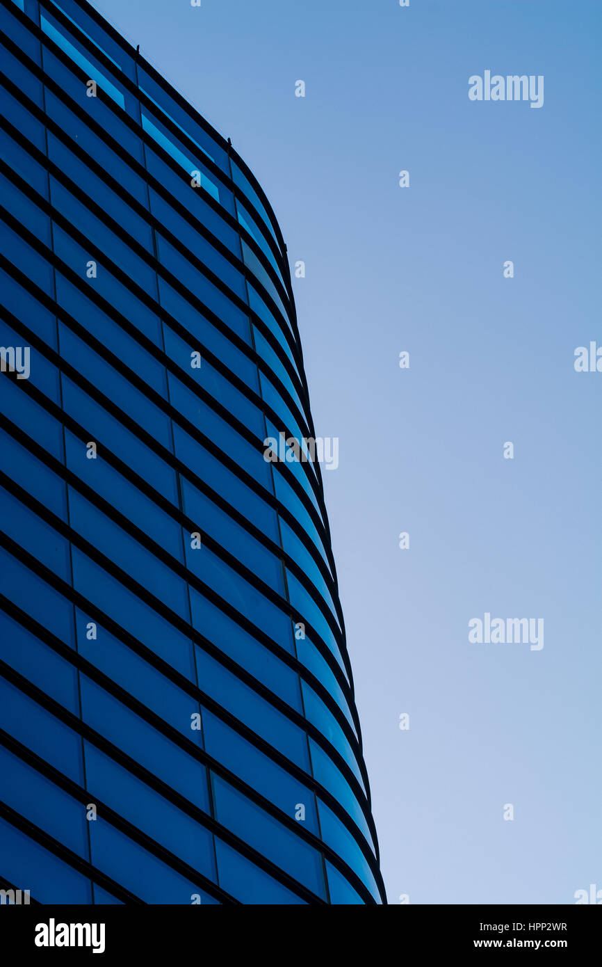 La façade de l'immeuble moderne en verre contre Ciel Bleu clair Banque D'Images