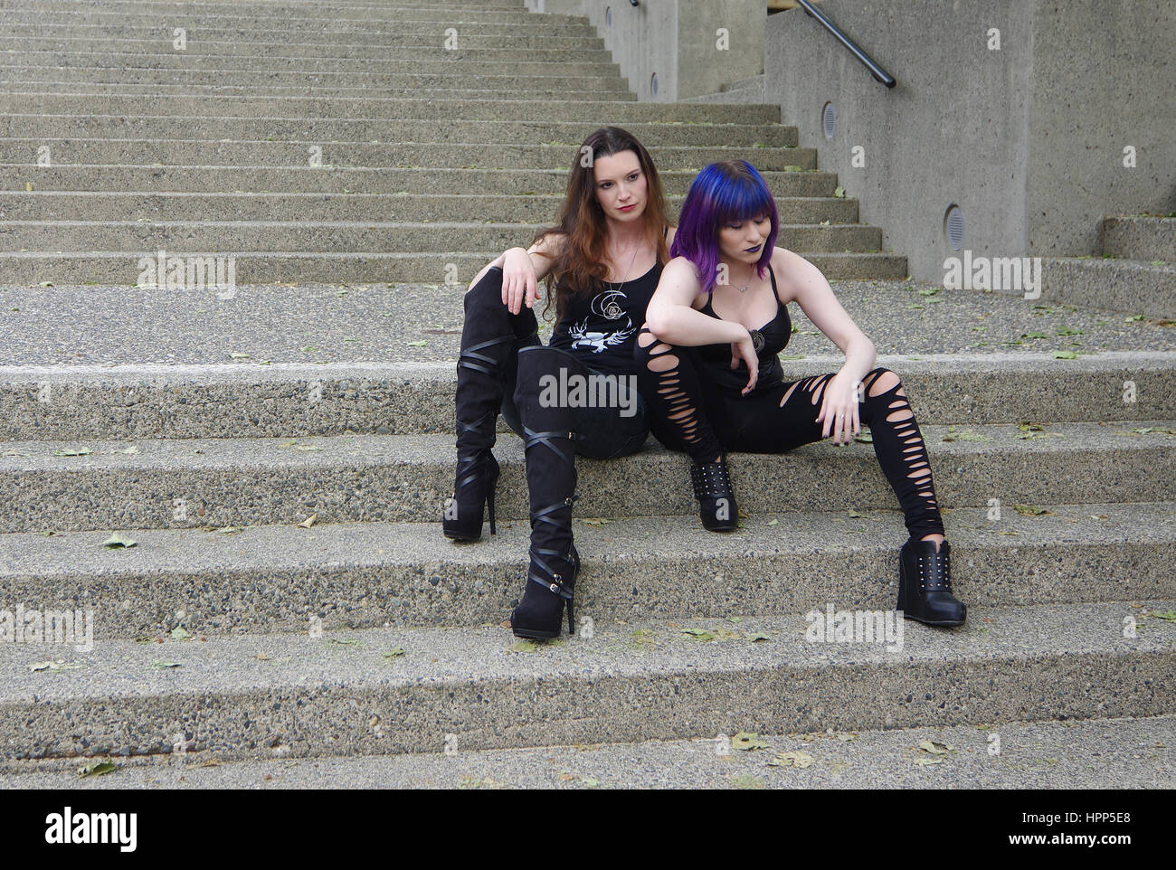 Deux femme assis ensemble sur un escalier en béton dans la ville Banque D'Images