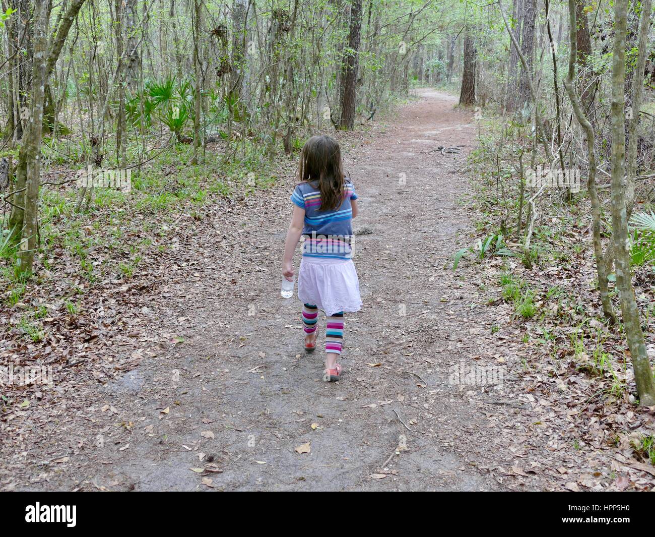 Jeune fille avec une bouteille d'eau de la randonnée à travers les bois, Gainesville, Floride, USA Banque D'Images