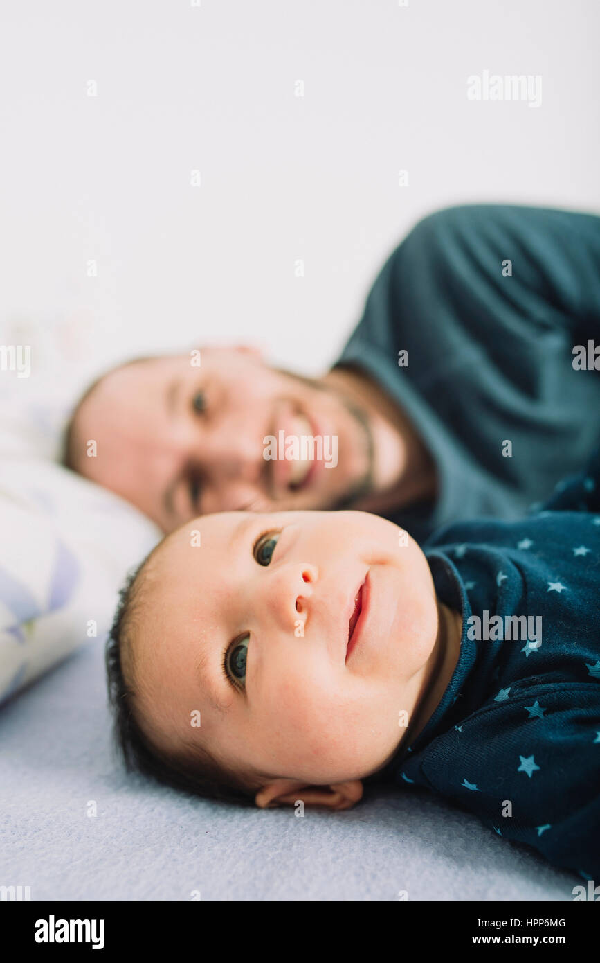 Heureux père au lit avec sa fille de bébé nouveau-né Banque D'Images