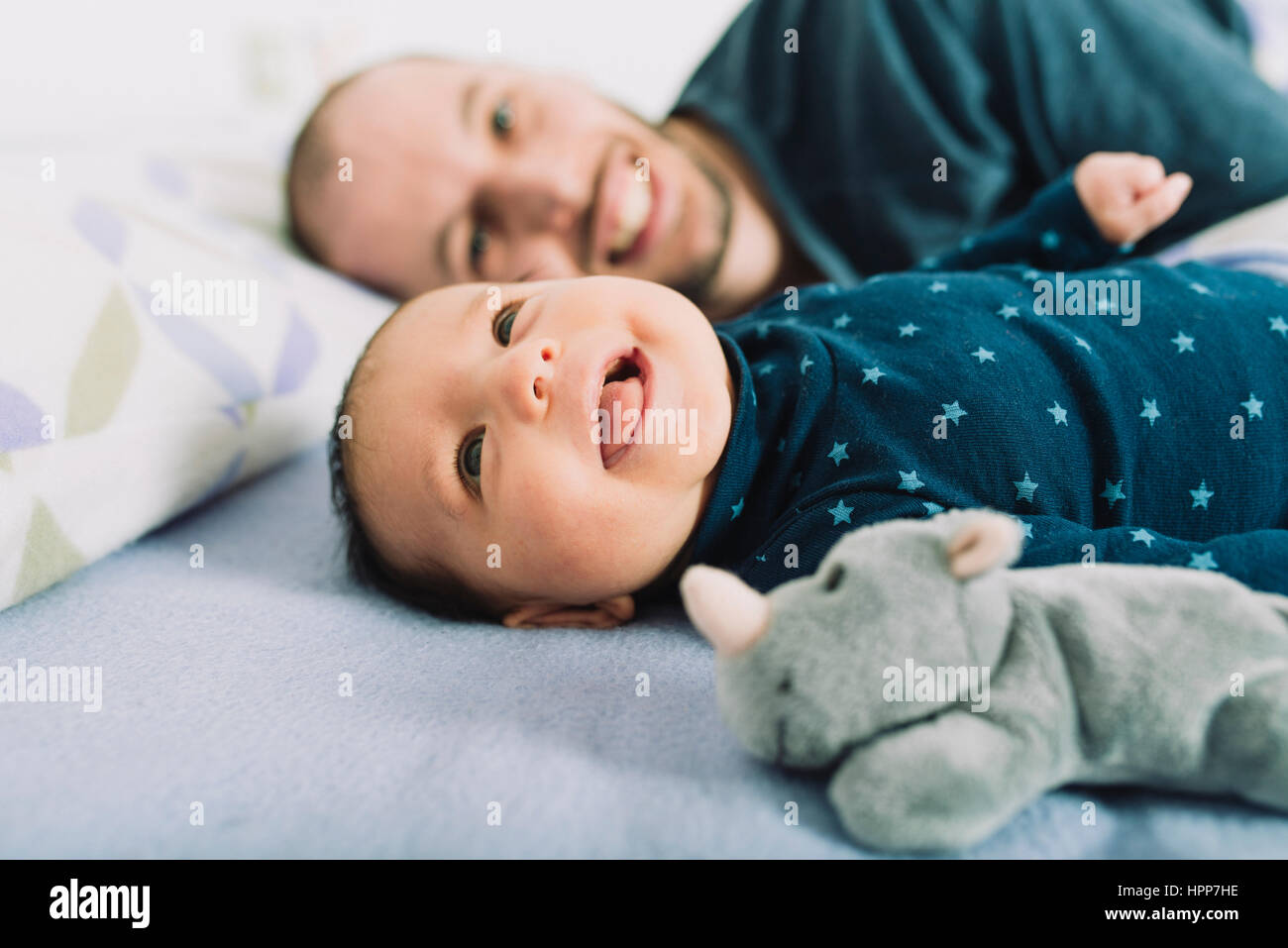 Heureux père au lit avec sa fille de bébé nouveau-né Banque D'Images