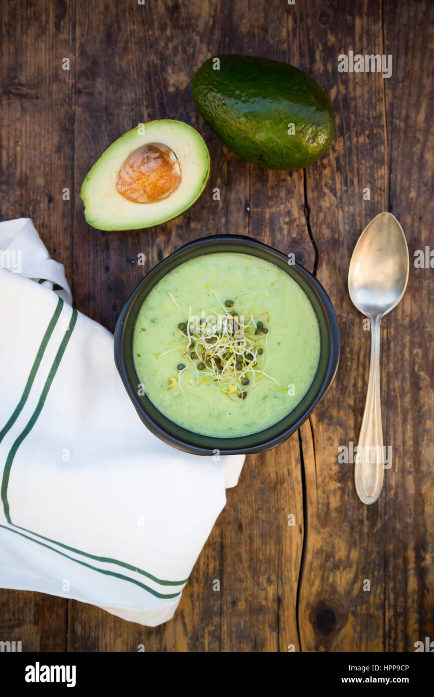 Bol de soupe de concombre avocat garni de pousses Banque D'Images