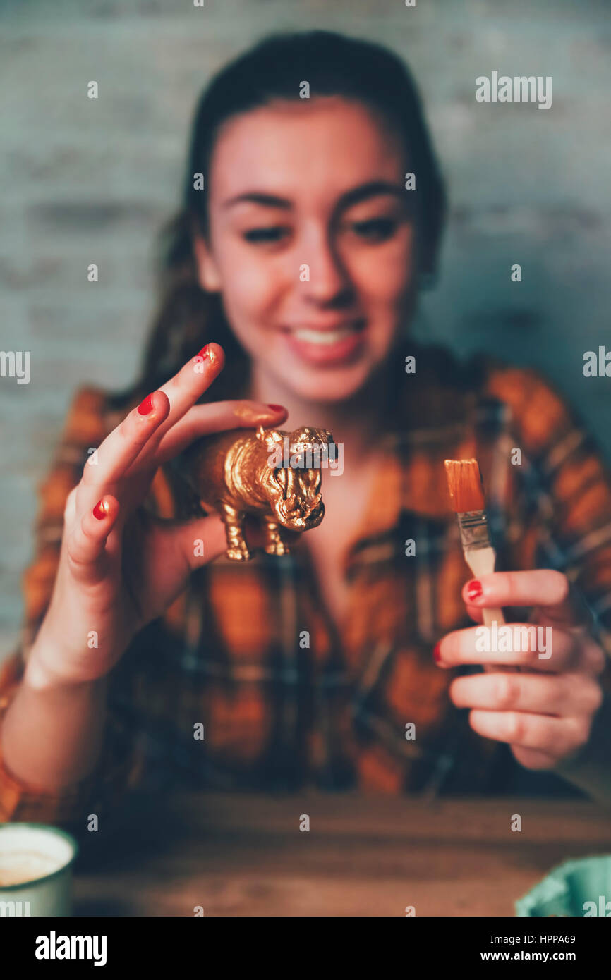 Jeune femme hippopotame peinture peinture or avec la figure en plastique Banque D'Images