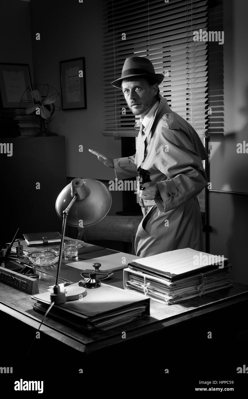 Détective attrayant braquer une arme à côté d'un 24, 1950 Bureau de style. Banque D'Images
